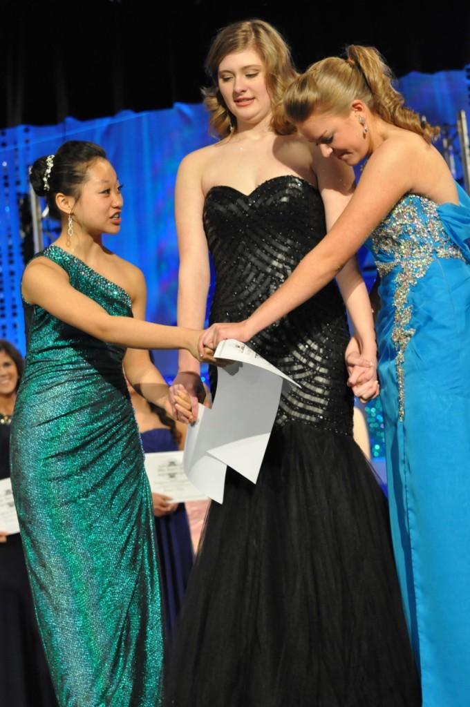 After three long nights of talent, casual wear, evening wear, and interviews,  freshman Yuri-Grace Ohashi (left), junior Camille Edwards (middle), and junior Abby Feltner anxiously hold hands and wait for the final results.  