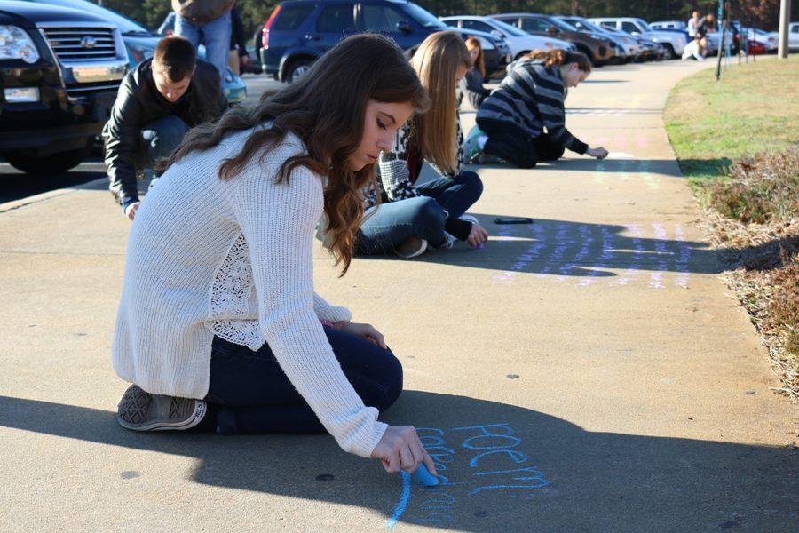 Jan. 25, 2017 - A senior in Jillian Bowen’s creative writing class writes her “Carpe Diem” poem with sidewalk chalk. The class spent the period writing and drawing on the sidewalk leading out of the attendance office to the student parking lot.  
