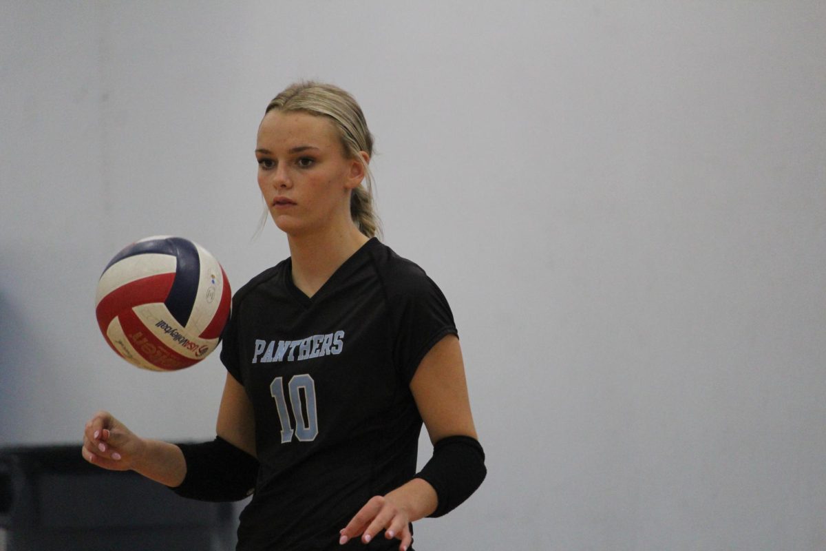 Freshman Aftyn Heiden tosses the volleyball. She was one of the key players in the game, having a strong presence at the net.