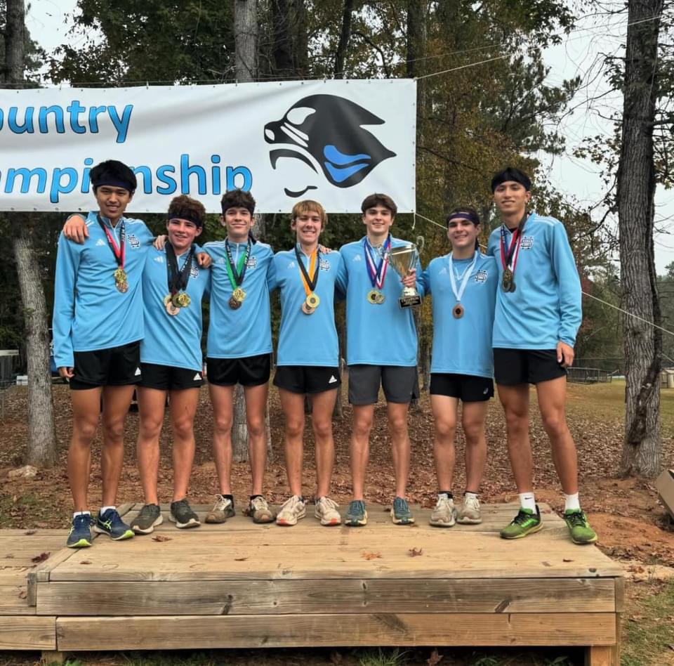 Boys cross country team on the podium. Both cross country teams qualified for state following the sectionals meet hosted at One Church.