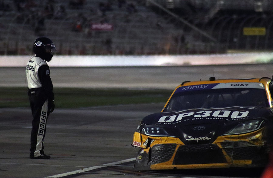 NASCAR race official looks at a damaged car during the Bennett Transportation and Logistics 250 Xfinity Series. After holding off Justin Allgaier and Aric Almirola in the closing laps, Austin Hill won the race for the second year in a row.